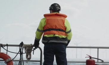 Man Pa Båt Tittar Pa Vindkraftverk COT 366X220