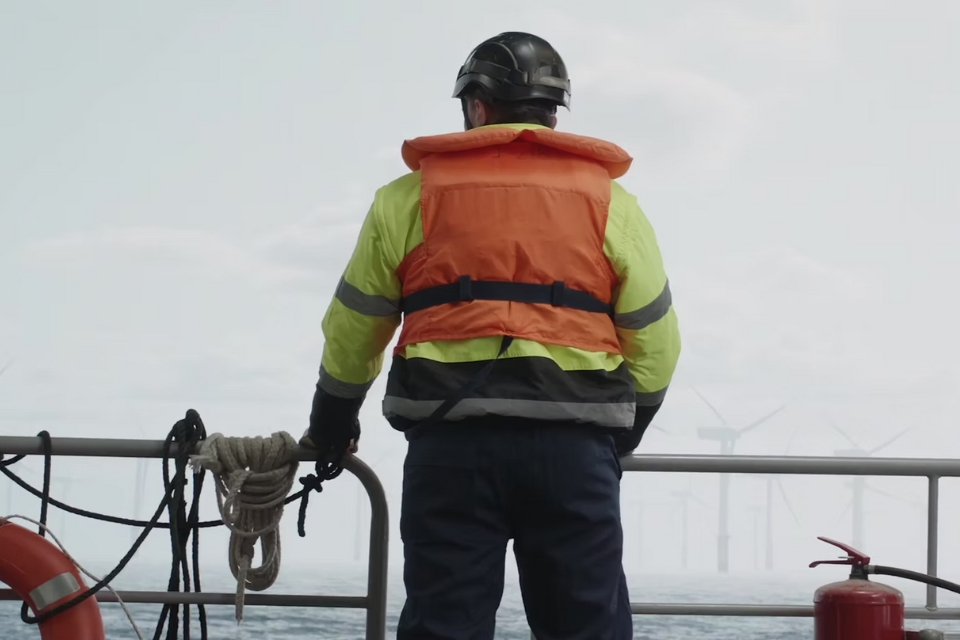 Man Pa Båt Tittar Pa Vindkraftverk COT 960X640px