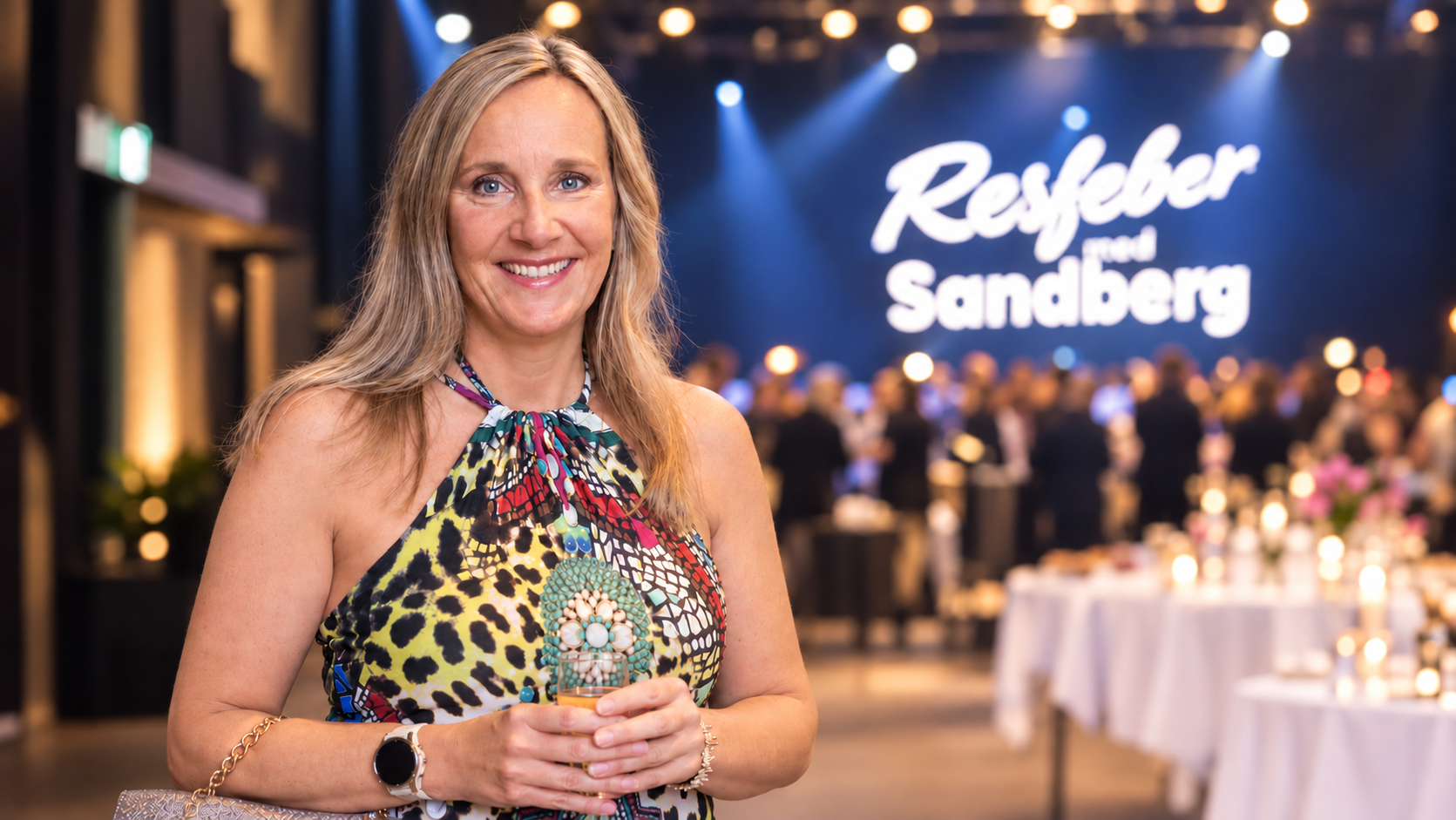 Jenny Nilsson framför Resfeber-bakgrunden på Sandberg Developments firmafest.