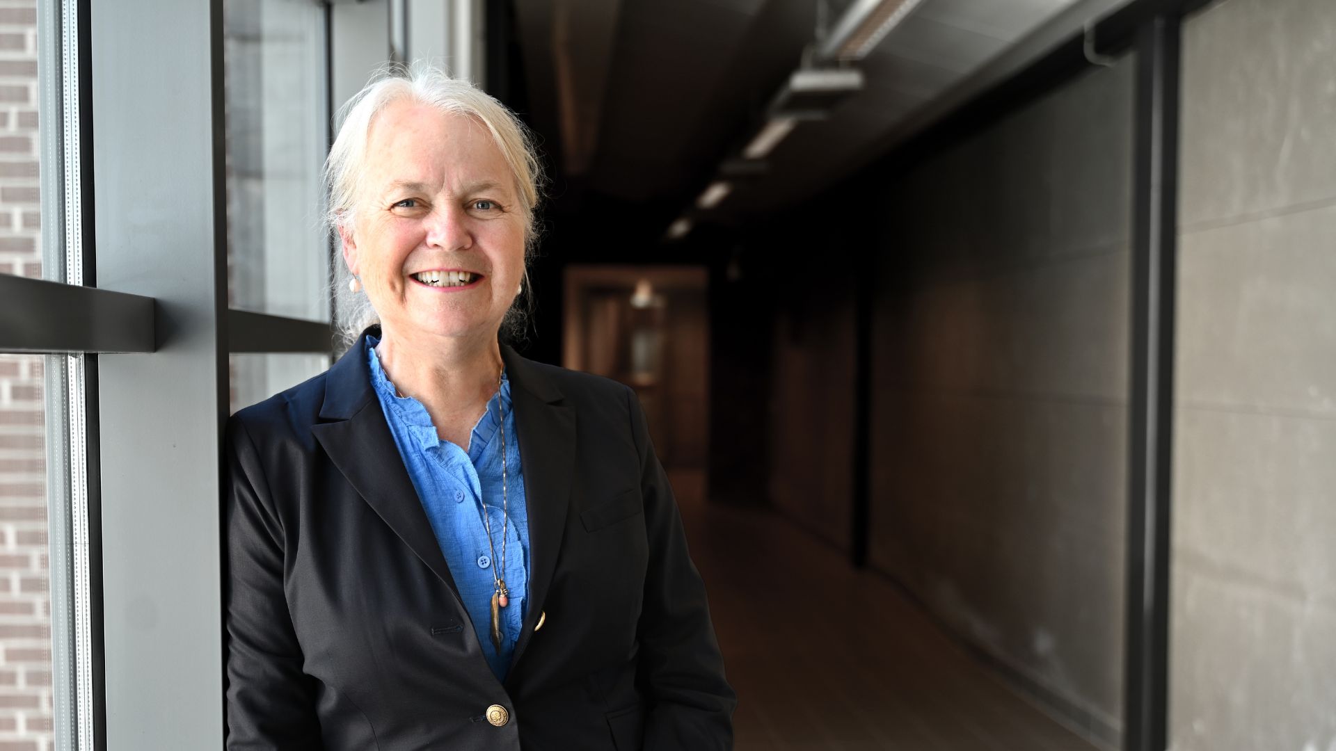 Porträttbild på Gunilla Westergren-Thorssons, forskare inom KOL på Lunds Universitet, som står lutad mot ett fönster och ler.