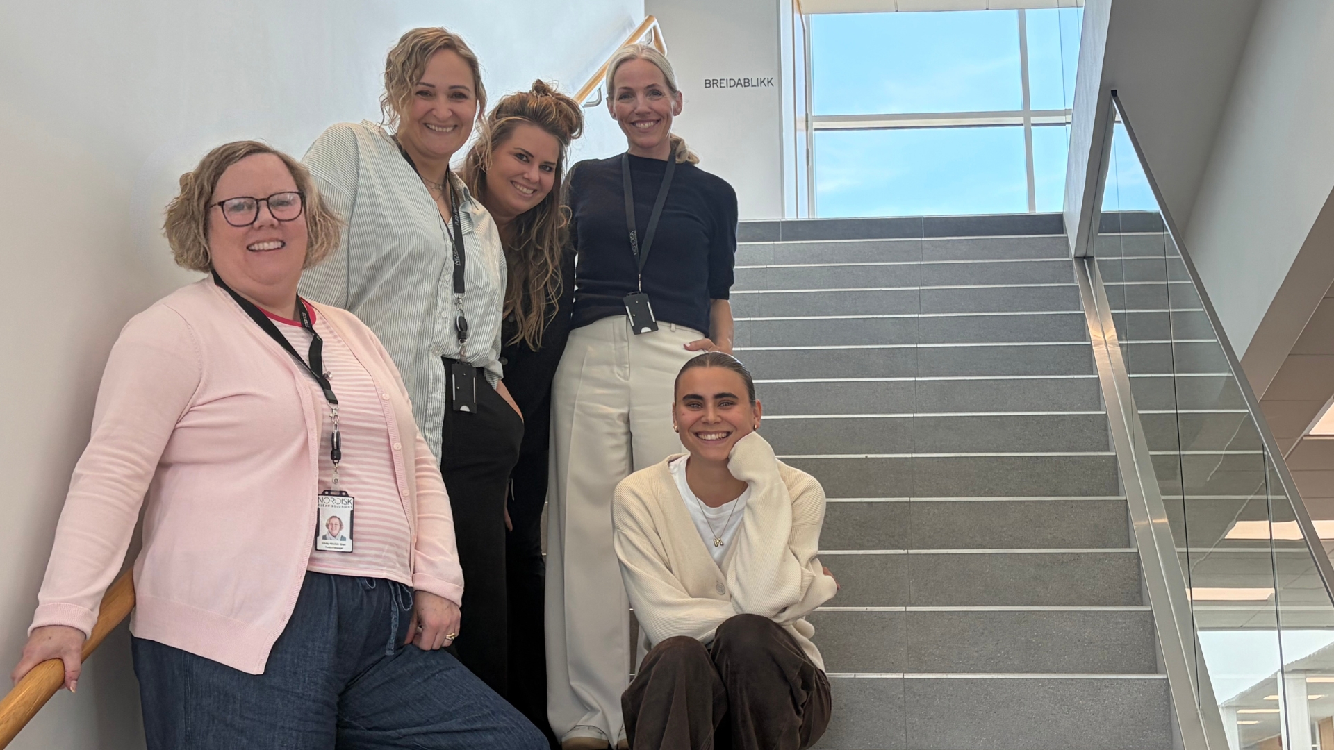 Nor:disks marknadsteam - Ulrika, Jessica, Caroline, Anna och Maja - står och sitter i en trappa och ler mot kameran. 